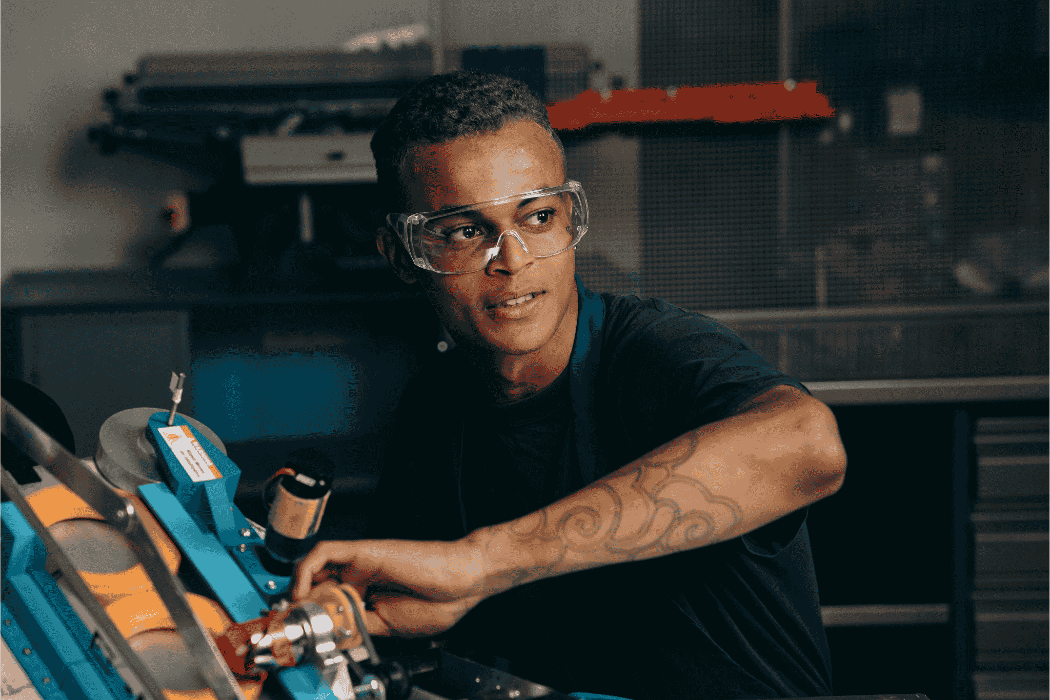 A Young Man in an Apron and Safety Glasses acting as a mechanic tool