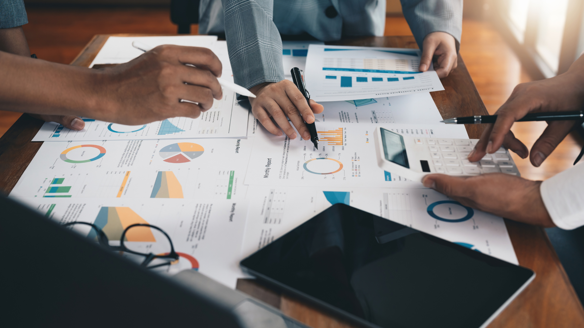 Team analyzing marketing data reports with charts, graphs, and a calculator—illustrating the role of food marketing data analysts in driving insights and strategy.