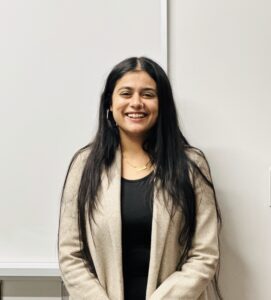 Head shot of Shubnam Kaur, smiling against a neutral background