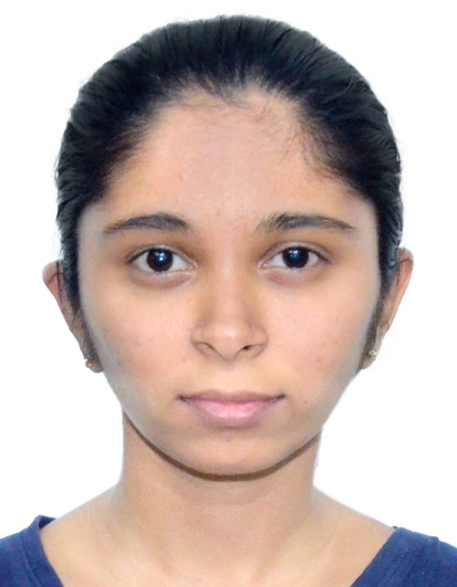Headshot of a young woman with dark hair pulled back, wearing small earrings and a dark top, looking at the camera against a plain light background.